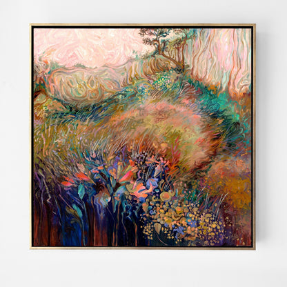 A framed abstract landscape painting featuring a soft, textured field of pink, green, gold, and blue tones, enclosed in a thin gold frame and displayed against a clean white wall.